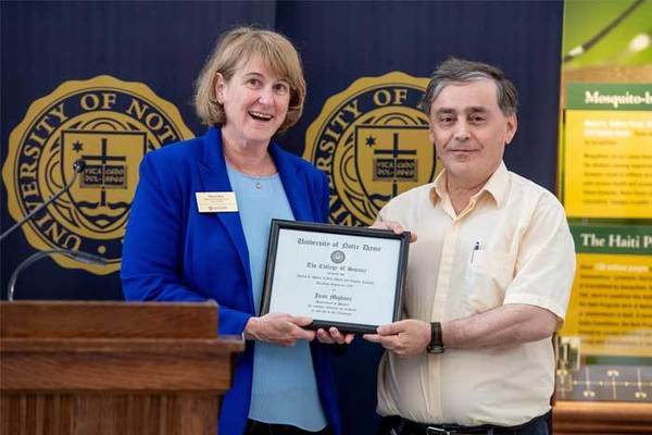 Mary Galvin, dean, honors Juan Migliore with Teaching Award certificate
