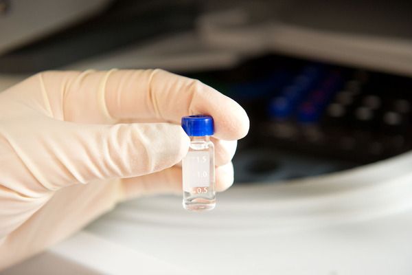 Hand holding tiny vial with clear liquid, Mass Spectrometry Facility
