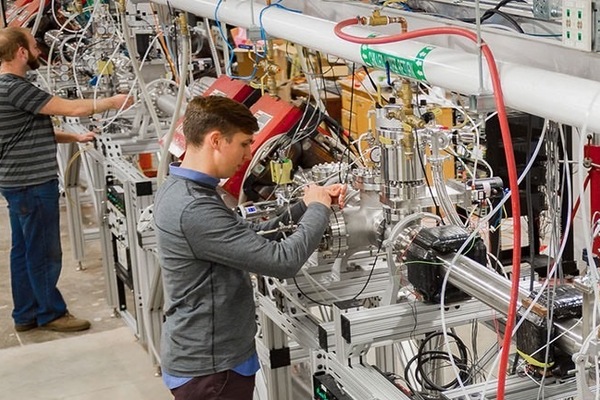 A student adjusts equipment in the Institute for Structure & Nuclear Astrophysics