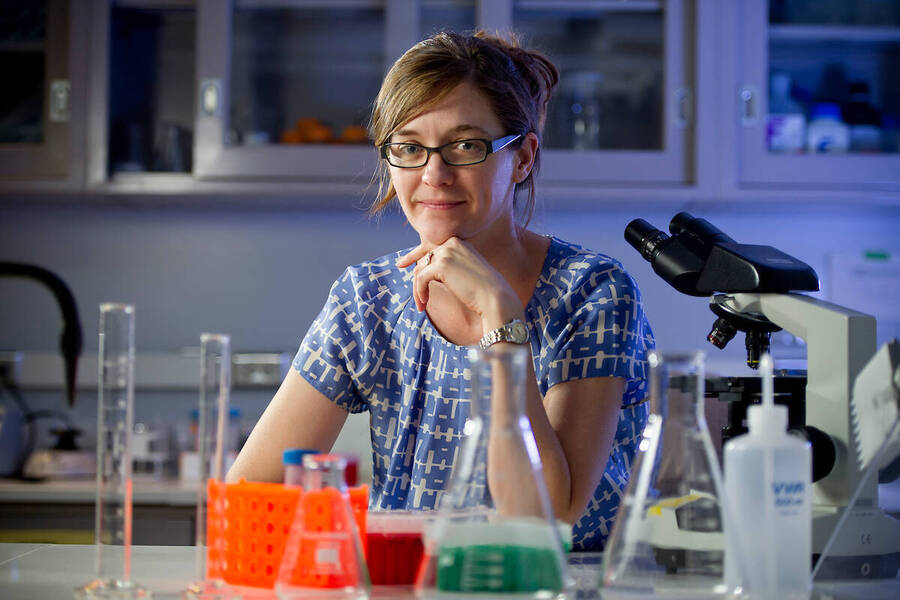 Beth Archie sits in a lab surrounded by research equipment