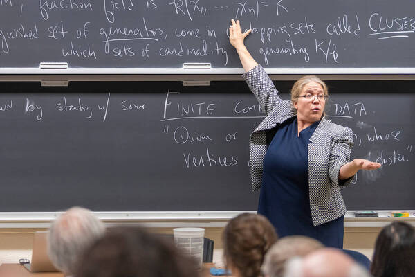 Math professor teaching in front of chalkboard