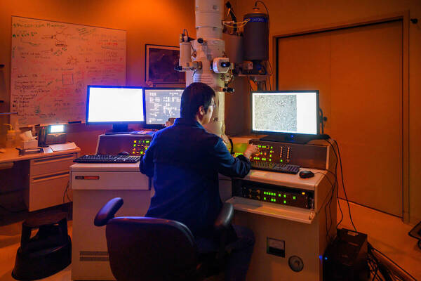 A researcher sits at a computer desk in the Integrated Imaging Center, the room is glowing orange
