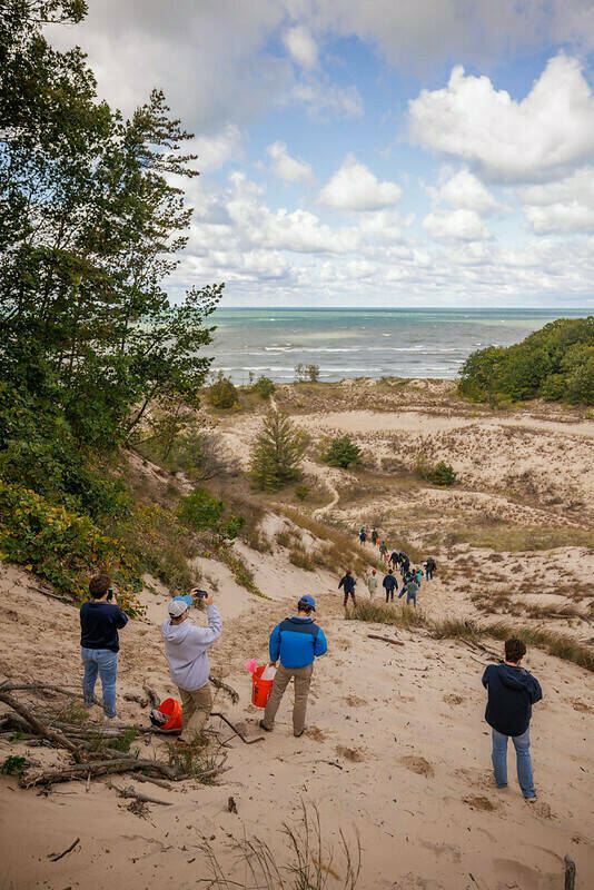 Ecology field trip: students run down the dunes toward the water at Warren Dunes State Park