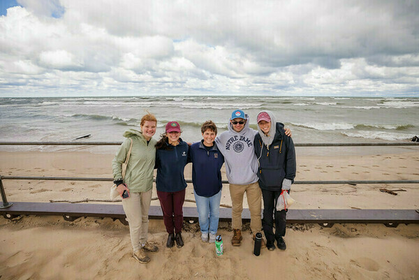 Ecology field trip: students stand along the shore of lake michigan