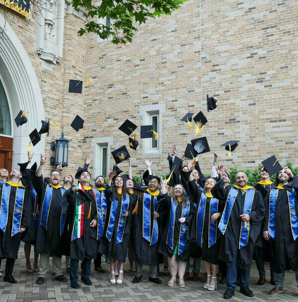 The Class of 2024 throwing their graduation caps at commencement.
