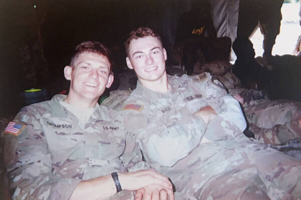 Smiling US Army ROTC cadets Thompson and Rulfo sit together. Rulfo crosses his arms.
