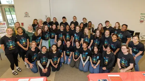 Smiling group wearing black Brain Awareness t-shirts with colorful brain logos at the Brain Awareness Fair at Howard Park.